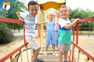 children smiling on playground equipment